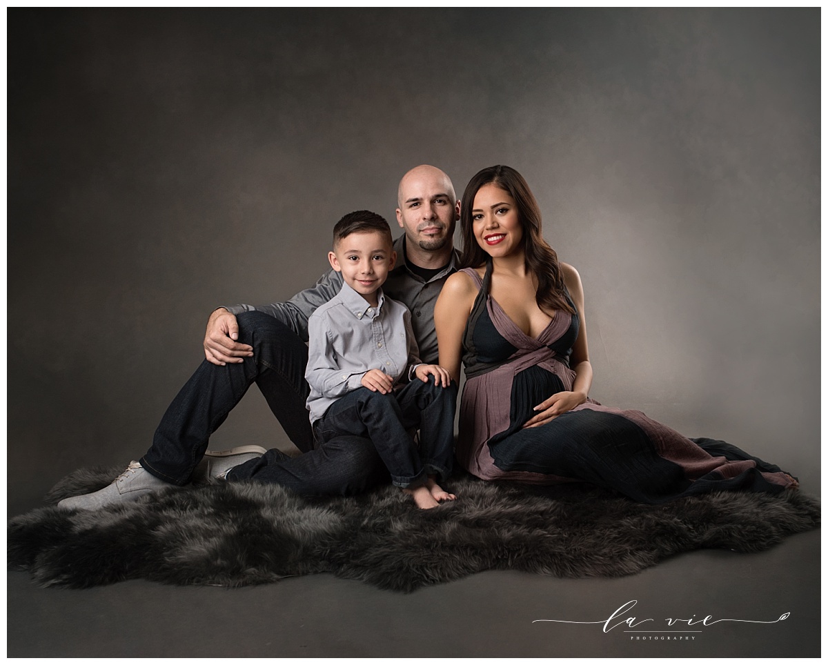 Studio maternity family portrait with grey tones