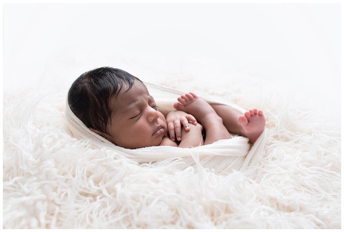 Backlit profile portrait of newborn baby girl on white
