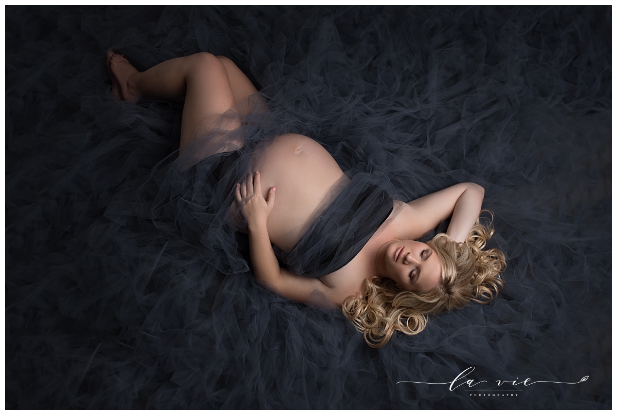 maternity portrait lying on blue tulle