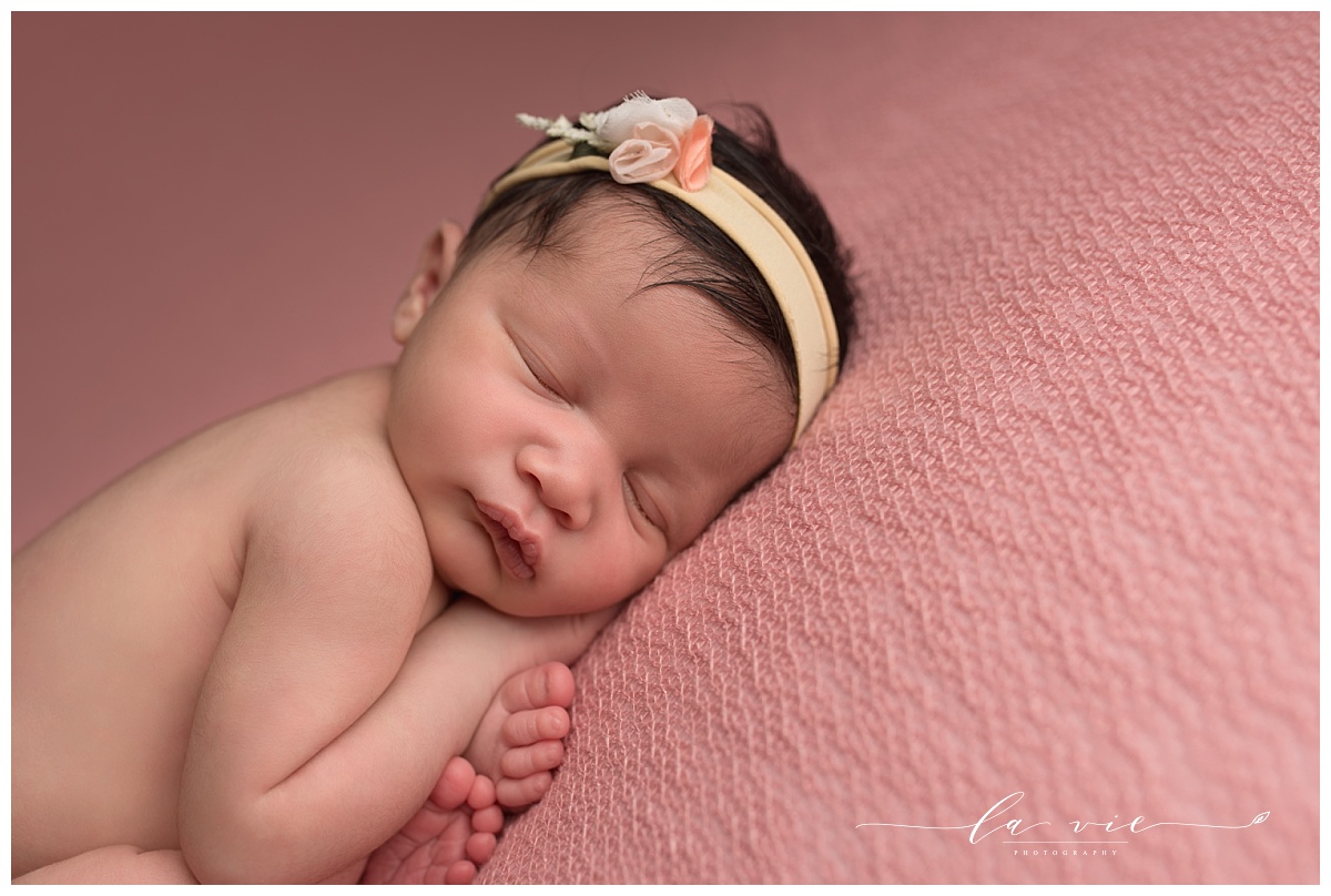 closeup of newborn baby girl with yellow flower headband